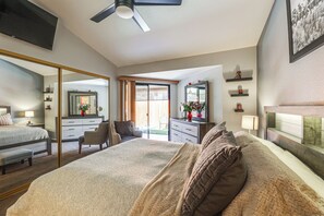A modern bedroom with a large bed, a ceiling fan, a sliding glass door to a balcony, and a large mirror. - Mesa Haven w/ Patio, Heated Pool & Hot Tub Access (Mesa)
