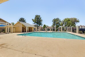 A swimming pool area with a clear blue pool, a covered seating area, and a fenced perimeter. - Mesa Haven w/ Patio, Heated Pool & Hot Tub Access (Mesa)