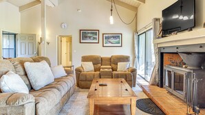 A cozy living room with a fireplace, a sofa set, and a coffee table. - Golf Course Getaway & Hot Tub Haven in Pinetop! (Pinetop)