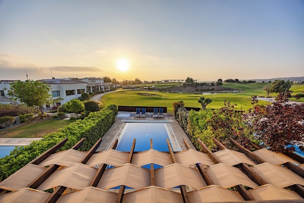 A poolside view with lounge chairs, a pool, and a golf course in the background. - Hg06 Adjacent to Aphrodite Hills- Private Pool (Kouklia)