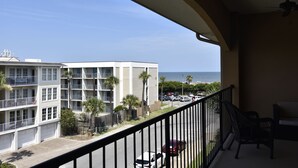 Ein Balkon mit Blick auf ein Gebäude und das Meer.