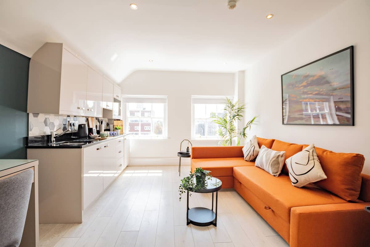 A modern apartment with a kitchen, living area, and large windows.