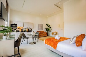 A modern hotel room with a bed, a dining area, a kitchen, and a living space. - Dublin Central Suites (Dublin)