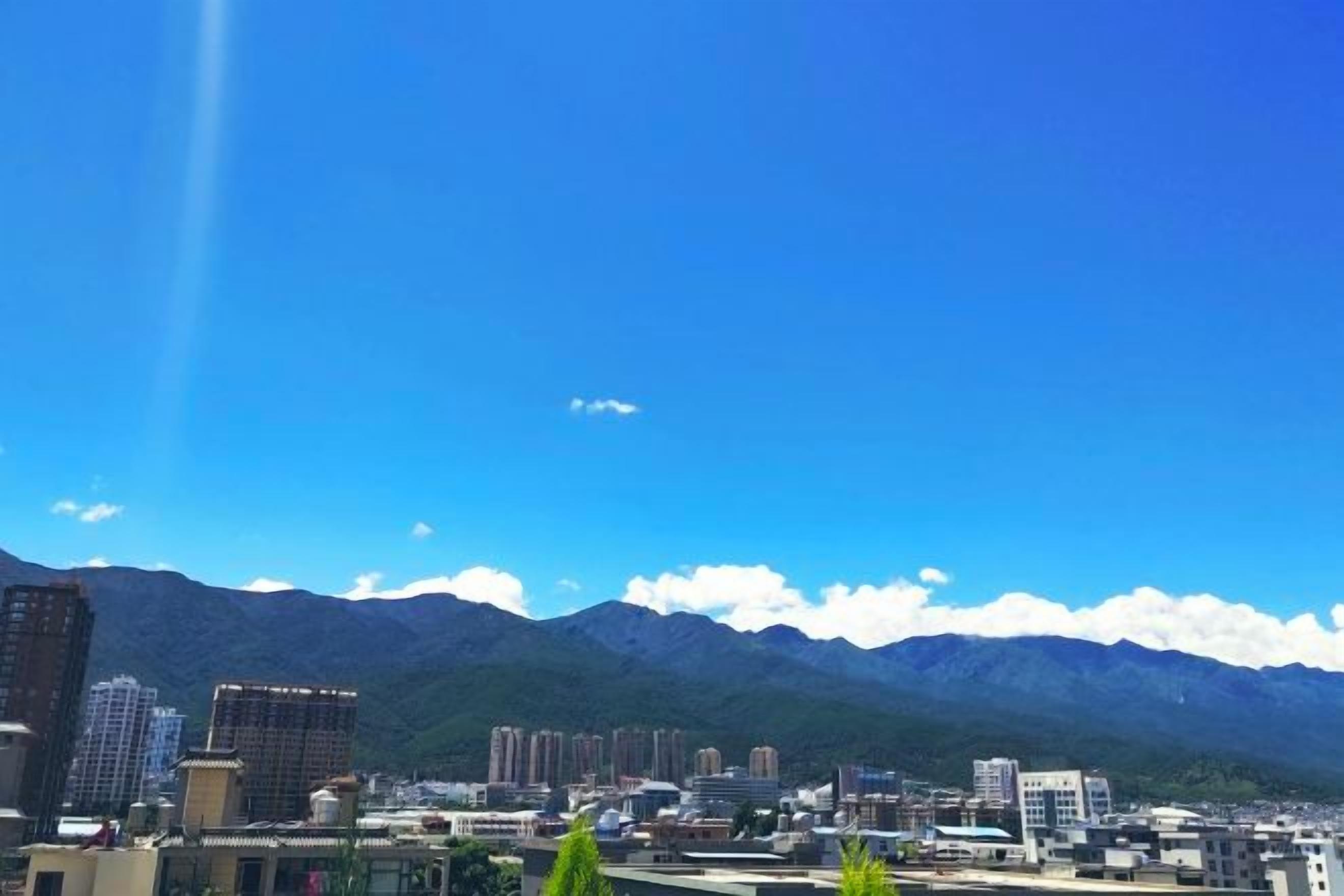 Un paisaje urbano con edificios y montañas al fondo.