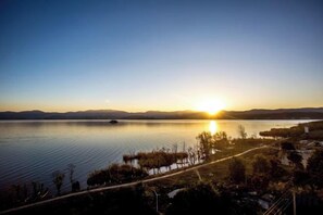 A lake with a path along the shore, surrounded by trees and hills in the background. - Dali Zouzou Tingting Seaview Inn (Dali City)
