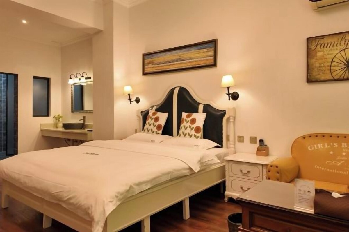 Un dormitorio ordenado con cama, mesitas de noche, cómoda y espejo montado en la pared.
