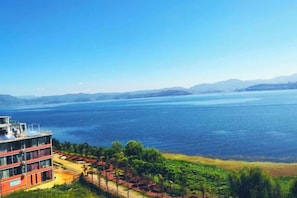 A hotel with a view of a large body of water and distant mountains. - Dali Zouzou Tingting Seaview Inn (Dali City)