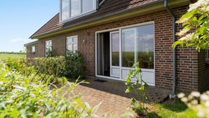 Een twee verdiepingen tellend huis van baksteen met een schuin dak, grote ramen en een gevel van baksteen.