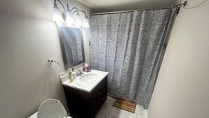 A bathroom with a toilet, sink, and mirror. - Townhome with Game Zone, Big Beds, & Smart TVs (Westmont)