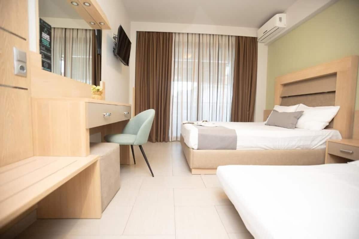 Una habitación de hotel con cama, escritorio, silla y televisor.