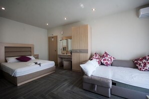 A modern hotel room with a bed, a sofa, a desk, and a wardrobe. - Amalia Center (Volvi)