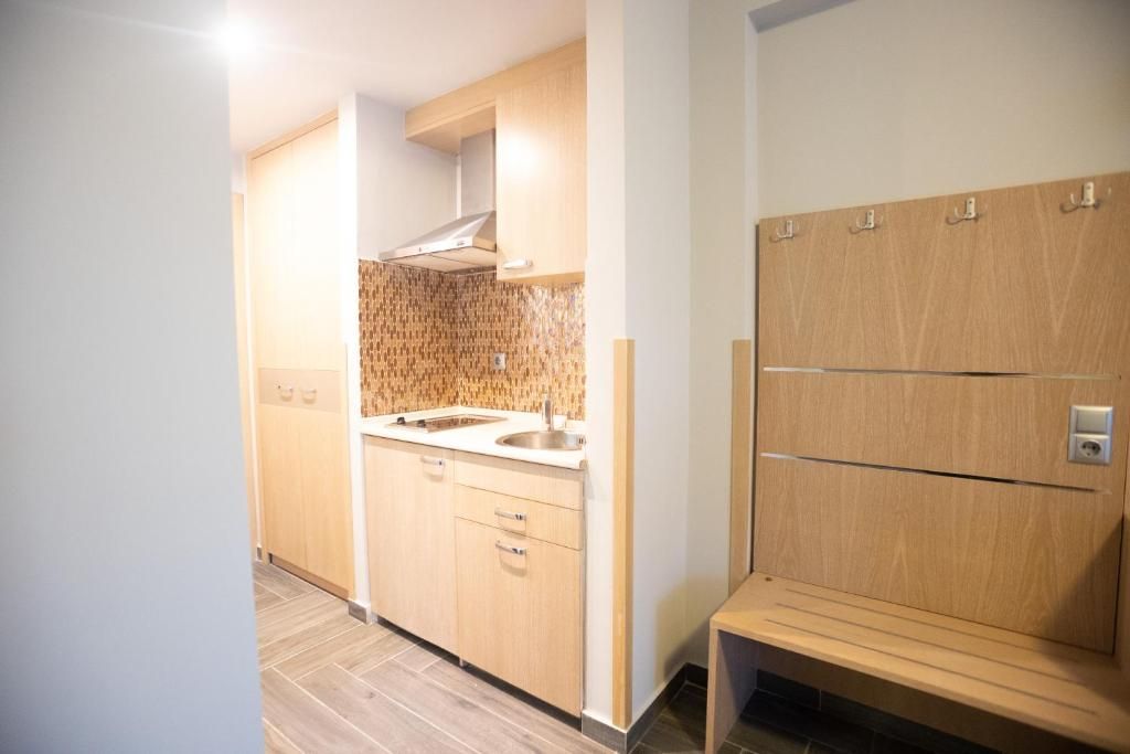 A modern kitchen with wooden cabinets, a stainless steel sink, and a built-in stove.