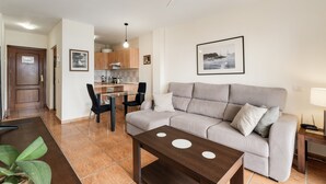 Una sala moderna con un sofá, una mesa de centro y un comedor con sillas y una mesa.