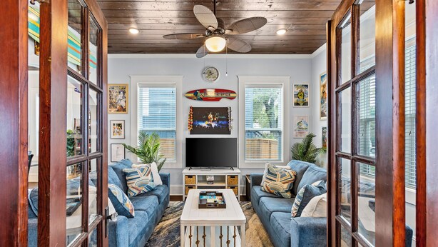 A living room with two blue sofas, a white coffee table, and a ceiling fan. - Private Pool & Hot Tub • 2 King Suites • No Cleaning Fee • Pet Friendly (Galveston)