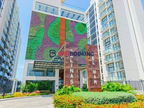 A modern building with a green and purple vertical garden, a sign reading 'BESTBOOKING.COM,' and the name 'ELMAR' on large metal pillars.