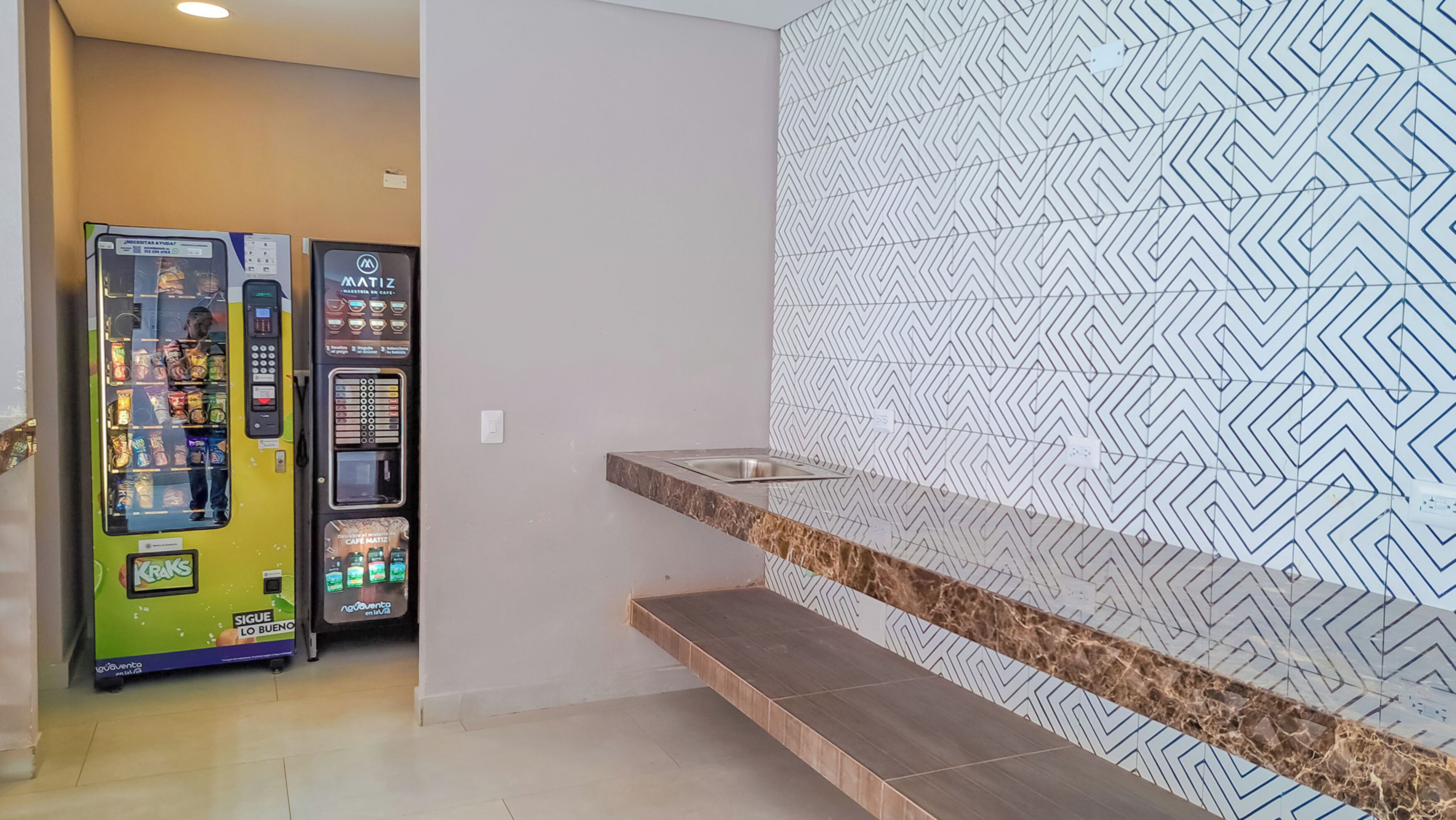 Une salle de bain moderne avec un mur à motifs, un comptoir en marbre et un lavabo.