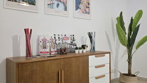 A wooden cabinet with drawers, a potted plant, and framed pictures on the wall. - Verso Maison - Incantevole alloggio a Gragnano (Gragnano)