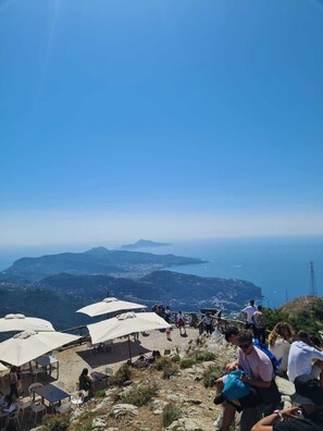 A scenic viewpoint with outdoor seating and a panoramic view of the coastline.