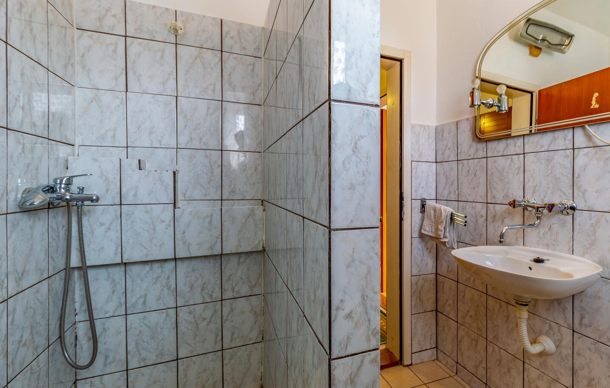 Un baño con ducha, lavabo y espejo.