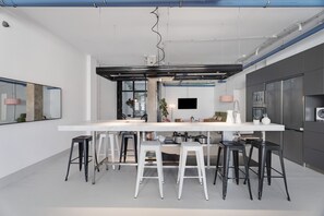 A modern kitchen with a central island, bar stools, and stainless steel appliances.