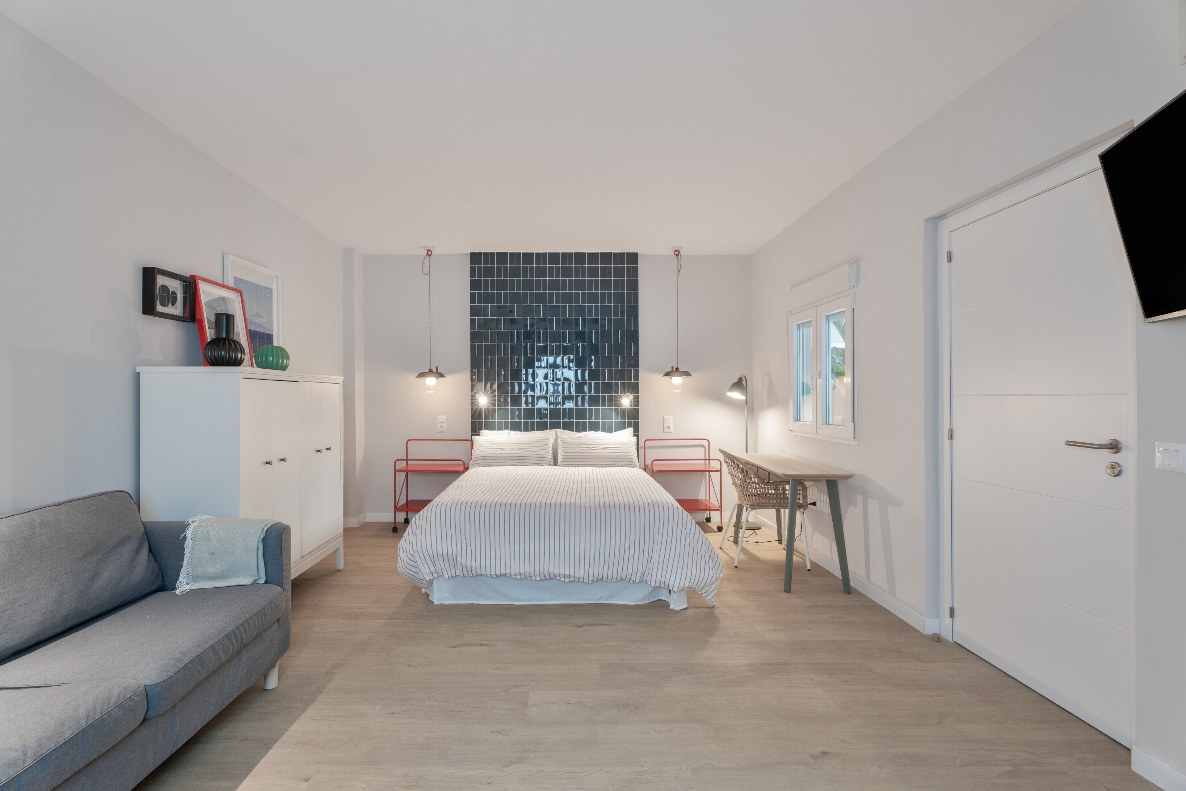 Una camera da letto con un letto, un divano, una scrivania e una televisione.