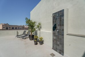 A rooftop terrace with lounge chairs, potted plants, a shower, and a tiled wall. - Suite Pescado Salado 7 with Shared Terrace and Wi-Fi (Santa Cruz)