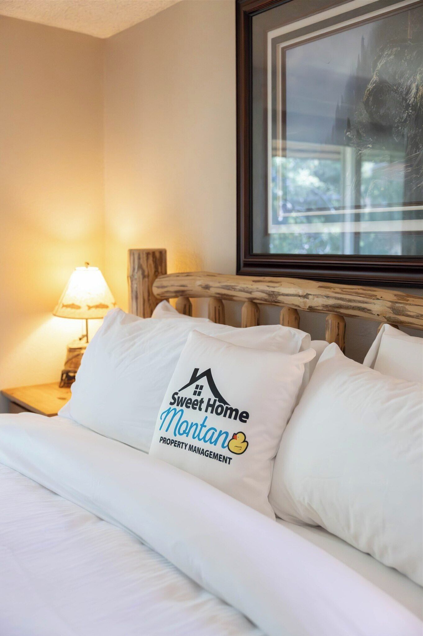 A hotel room with a bed, a nightstand with a lamp, and a window with a view.