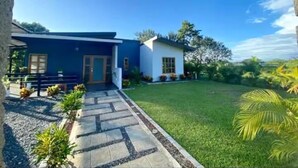 A modern two-story house with a blue exterior and a white front section.