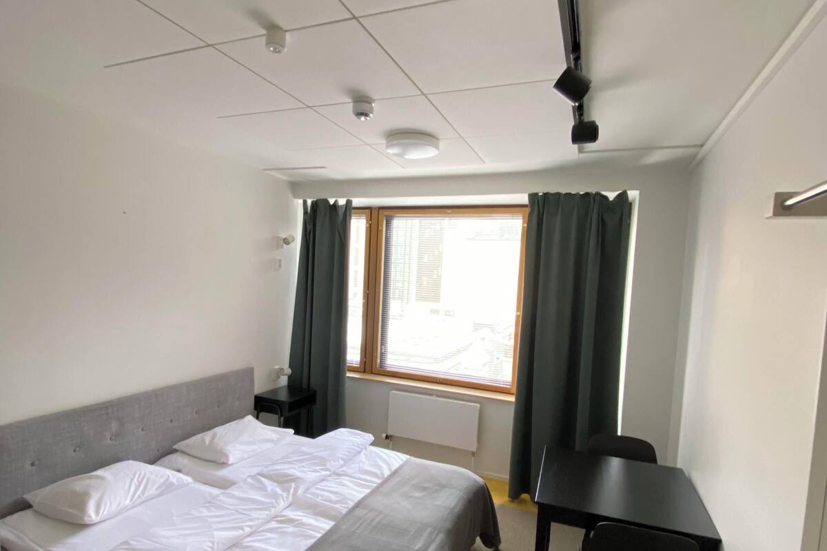Premium bedding, desk, laptop workspace, blackout drapes