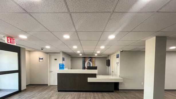 Un área de recepción con mostrador, señal de salida y cámara de seguridad.