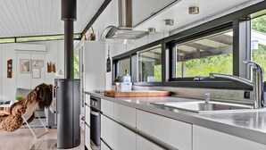 Una cocina moderna con un ventanal grande, electrodomésticos de acero inoxidable y un horno empotrado.