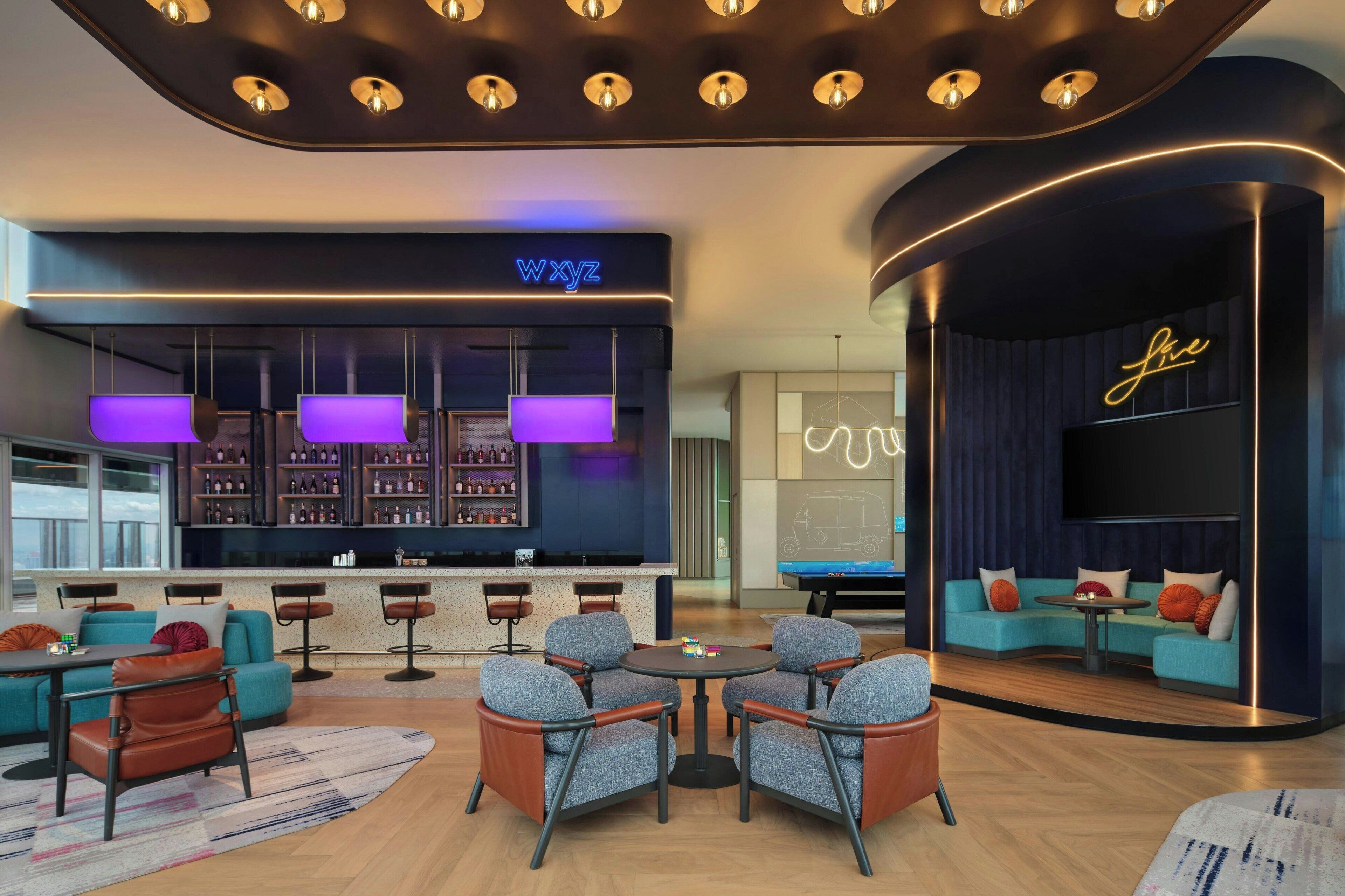 Een moderne lounge met een bar, zitplaatsen en een pooltafel.