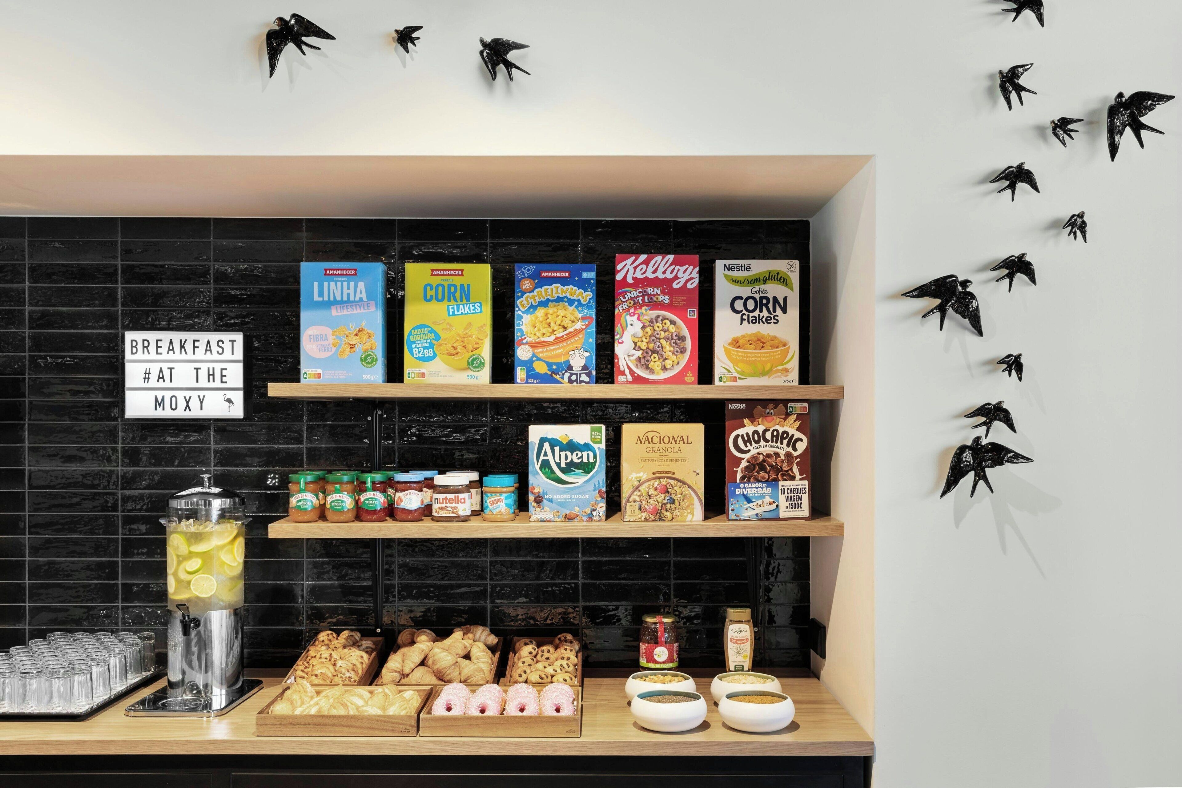 Una barra de desayuno con cajas de cereales, tarros de conservas y pasteles.