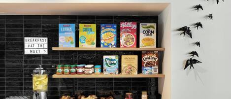 Una barra de desayuno con cajas de cereales, tarros de conservas y pasteles.