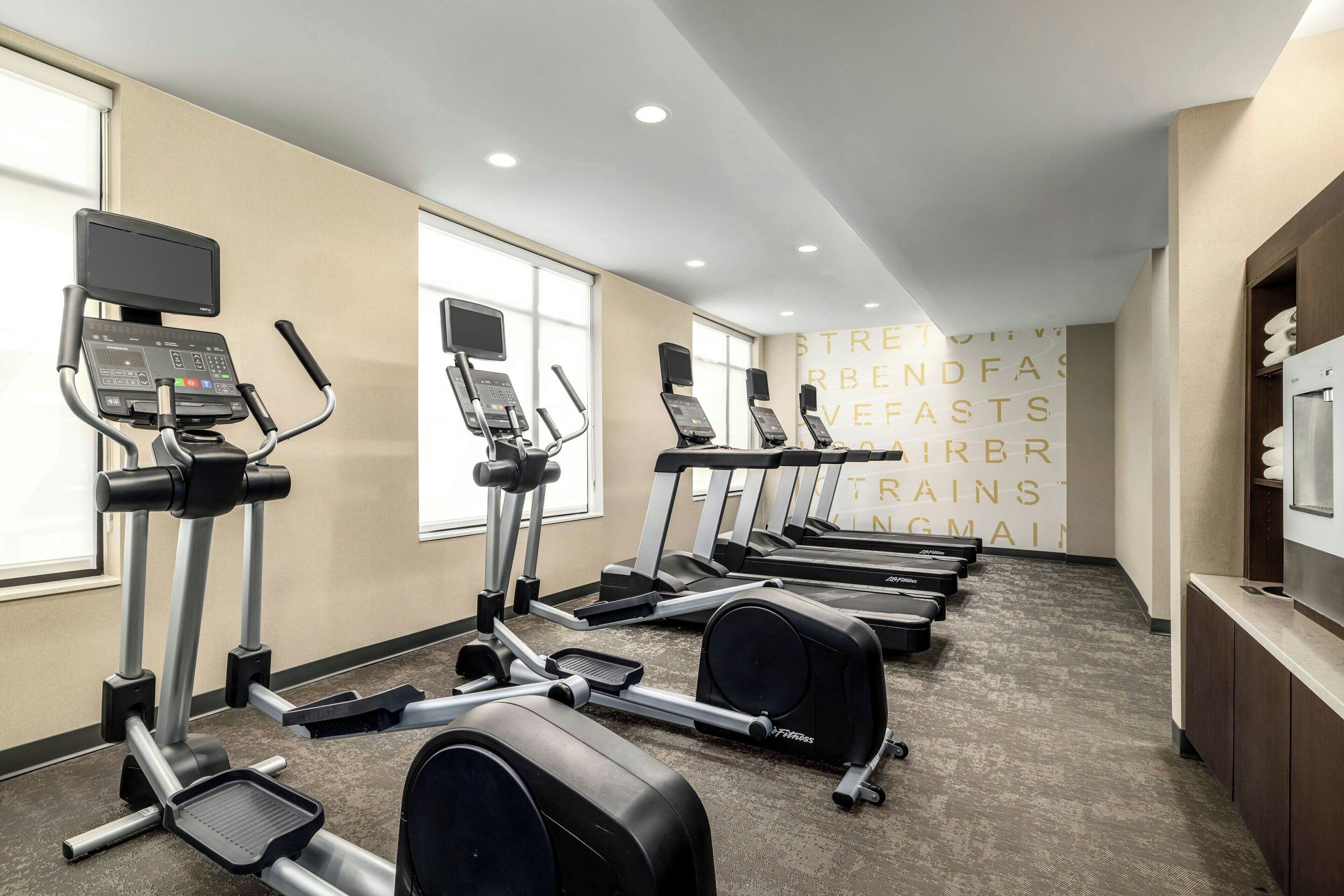 A gym with multiple treadmills, elliptical machines, and a stationary bike.
