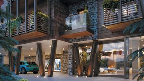 Un edificio moderno con fachada de piedra, grandes ventanales y un coche estacionado afuera.