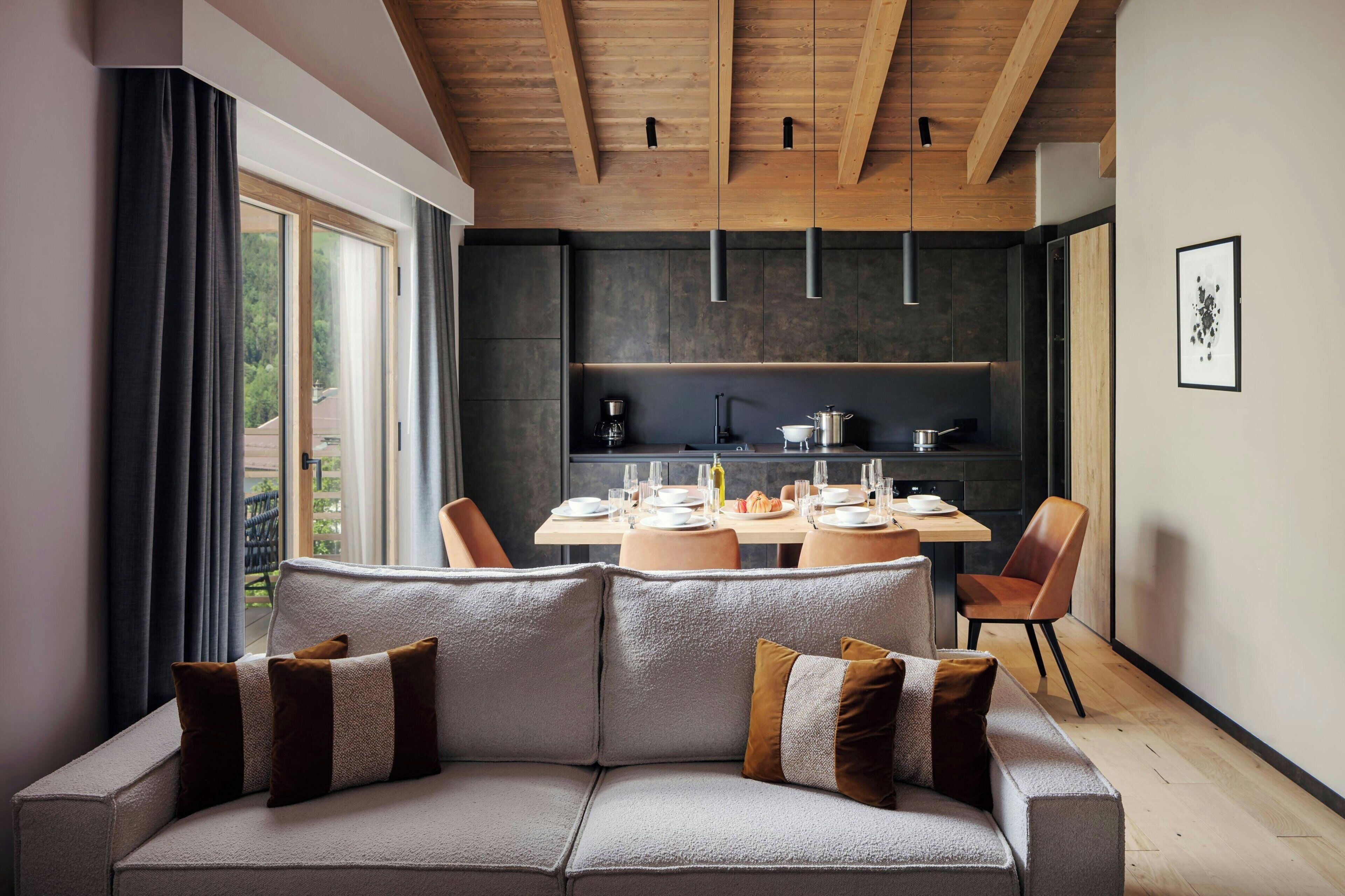Un interior moderno con sofá, mesa de comedor y zona de cocina.
