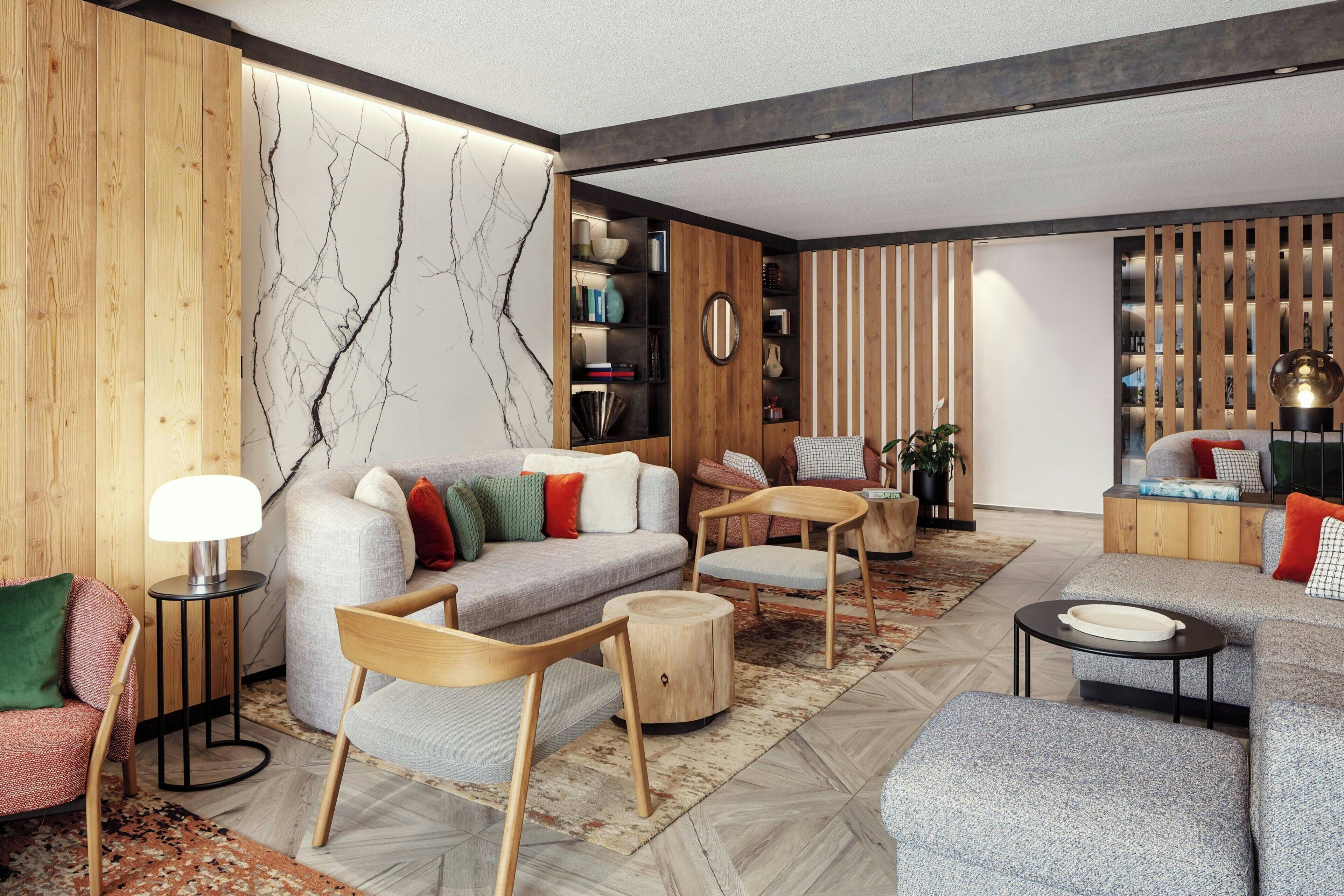 Un salon moderne comprenant un canapé, des fauteuils, une table basse et une bibliothèque.