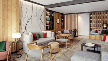 Un salon moderne comprenant un canapé, des fauteuils, une table basse et une bibliothèque.