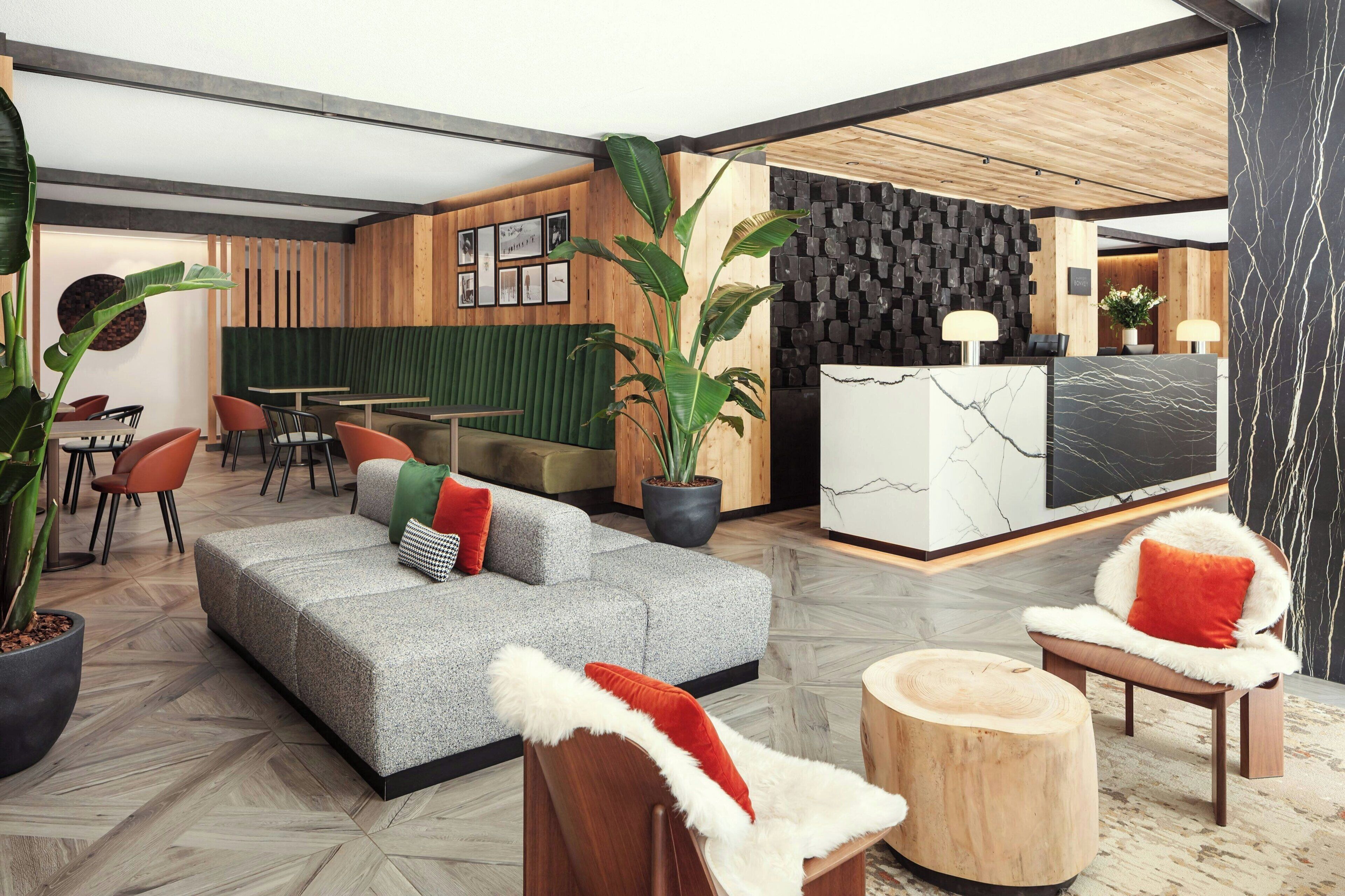 A modern interior with a reception desk, seating area, and a wooden wall.