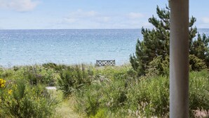 A coastal view with a wooden structure in the distance, surrounded by greenery and trees. - 3 bedroom lovely home in Knebel (Knebel)