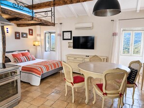 Ein Schlafzimmer mit Bett, Fernseher und Fenster mit Blick.