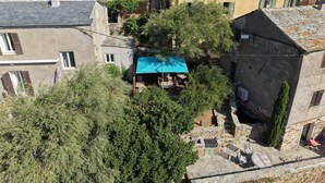 A residential area with stone buildings, a blue-roofed structure, and a tree. - LATU CORSU – Cosy studio for 2 (ERSA)