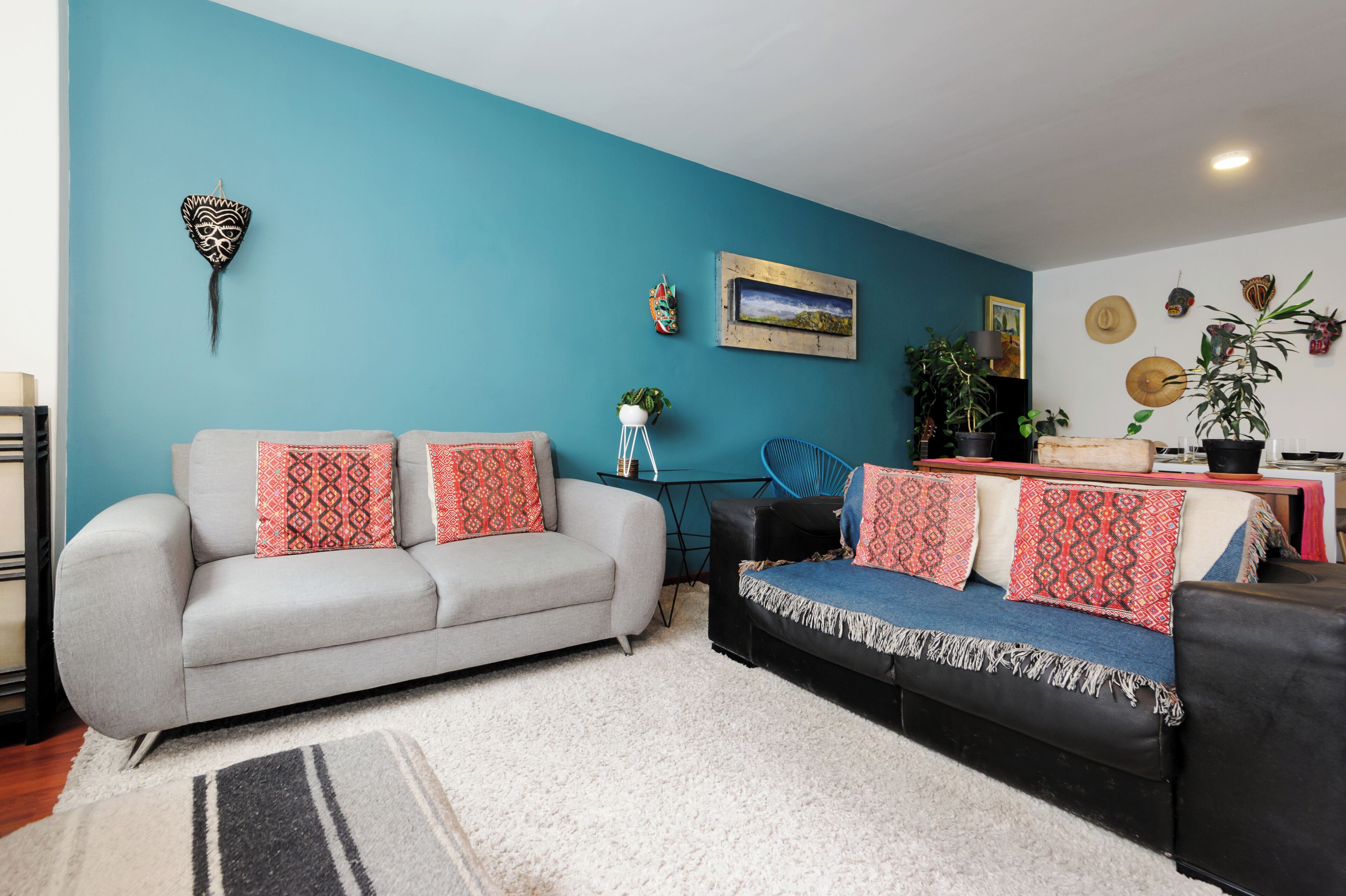 A living room with two sofas, a coffee table, and a blue accent wall.