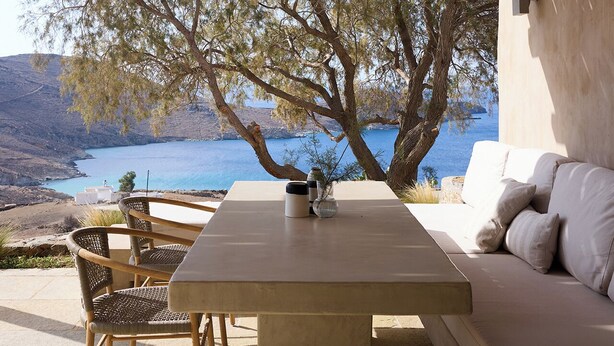 An outdoor patio with a wooden ceiling, a table, chairs, and a sofa. - Mousti's Cell Traditional Cycladic Farmhouse (Serifos Island)