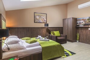 A hotel room with a bed, a chair, a desk, a lamp, a TV, and a framed map on the wall. - Parl Hotel Bükfürdő (Buk)