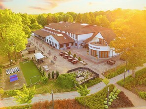 A hotel with multiple buildings, outdoor seating, and a tennis court. - Parl Hotel Bükfürdő (Buk)