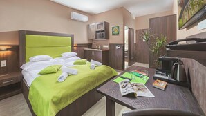 A hotel room with a bed, a desk, a microwave, a sink, and a plant. - Parl Hotel Bükfürdő (Buk)