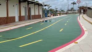 Een straat met een groene fietspad, een voetpad, en een gebouw met een betegelde gevel.