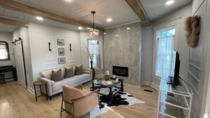Una sala de estar moderna con sofá, mesa de centro y mueble para televisor.